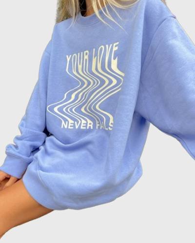 Love Never Fails Blue Unisex Crewneck: Spread love and positivity with this blue unisex crewneck, featuring a powerful message for a stylish and uplifting look.