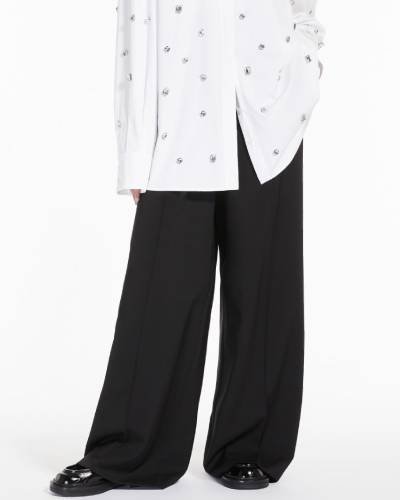Elevate your style with these Oversized Stretch Wool Trousers, a blend of comfort and fashion. The trousers feature a relaxed fit and stretchy wool fabric, making them a versatile and trendy choice for a modern and chic look.
