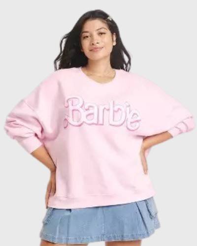 Pink women's sweatshirt featuring Barbie logo graphic, adding a touch of nostalgia and style.